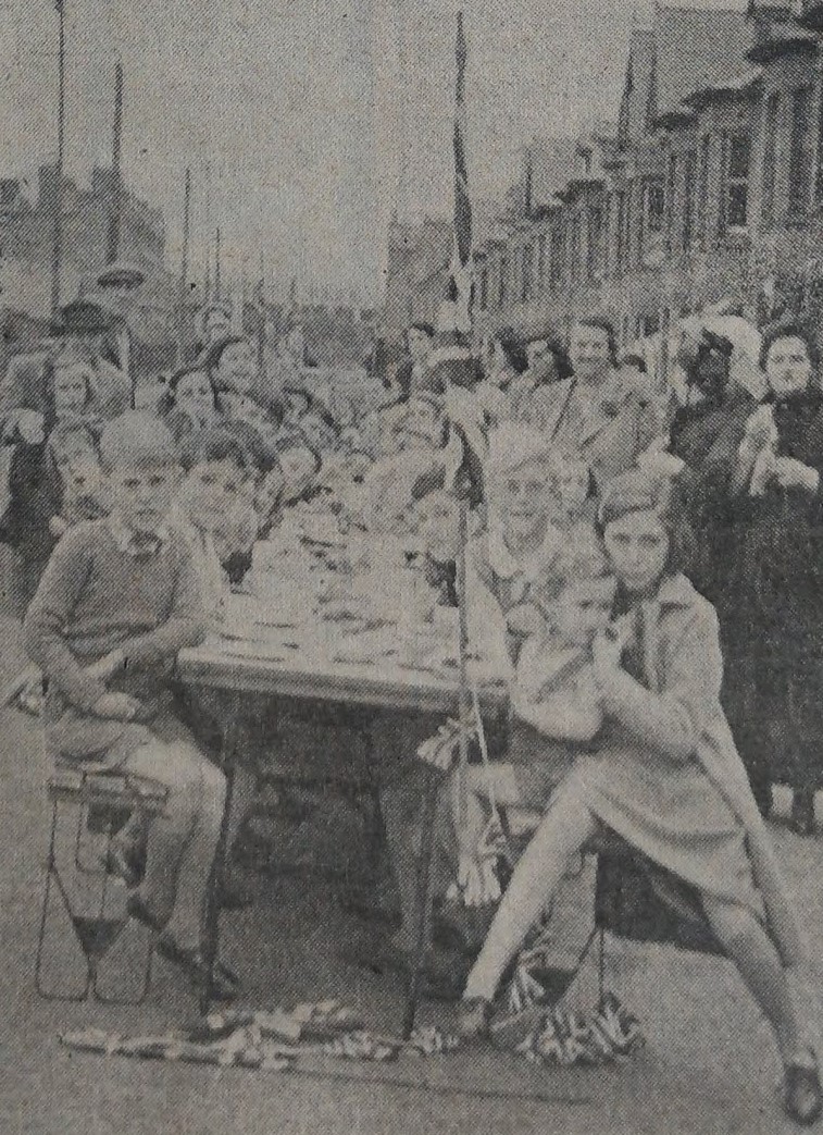 Children pose for the camera whilst having tea for VJ day on Bayford Road