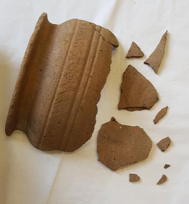 the shoulder and some fragments of a large ceramic vessel. The decoration is very plain and primitive.