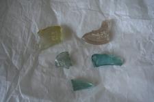 pieces of glass that were part of a spindle whorl, lie on a white background.