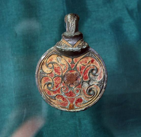 a metal bowl mount with red engraved detail in celtic swirls.